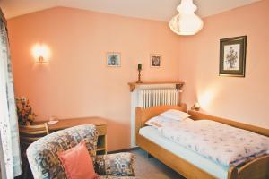 Stan's Bed & Breakfast في Untergriesbach: غرفة نوم صغيرة بها سرير وكرسي