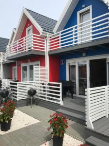 Casa blanca y azul rojo con porche y piano en Kotwisko en Sarbinowo