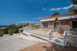 a stone house with a balcony and a walkway at Iliovasilema in Platy