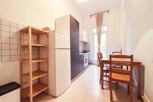 eine Küche mit einem Kühlschrank sowie einem Tisch und Stühlen in der Unterkunft Altbau-Schmuckstück an der Karli mit riesigem Balkon in Leipzig
