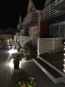 a building with potted plants on a patio at night at Kotwisko in Sarbinowo