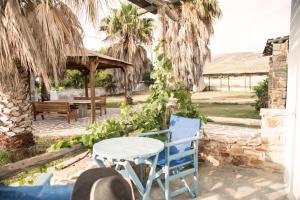 a patio with a table and chairs and a bench at Studios Vythos in Kastraki