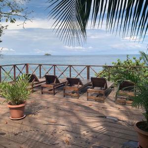 a group of chairs sitting on a patio overlooking the ocean at Hostal Hilltop Capurgana in Capurganá