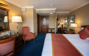 a hotel room with a bed and a chair at Killarney Towers Hotel & Leisure Centre in Killarney