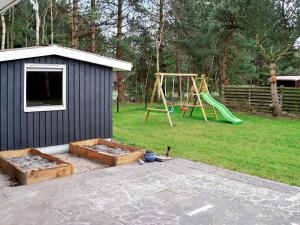 a backyard with a playground and a play house at 8 person holiday home in R dby in Kramnitse