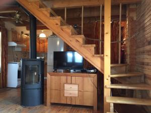 a living room with a tv and a staircase at Domek przy plaży in Narty