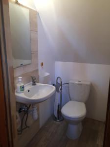 a white bathroom with a toilet and a sink at Domek przy plaży in Narty