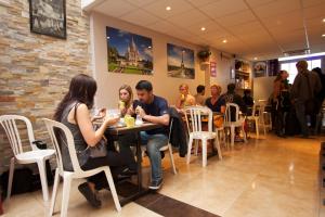 a group of people sitting at a table in a restaurant at Bastille Hostel in Paris