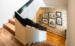 a staircase with a brick wall with pictures on it at Hotel Scheuble in Zürich