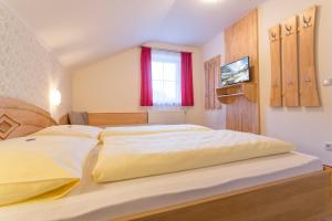 a bedroom with a large bed with a tv on the wall at Haus Sonnrain in Flachau