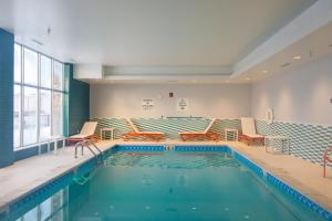 a swimming pool with orange chairs and a pool at Holiday Inn Hotel & Suites - Mount Pleasant by IHG in Mount Pleasant