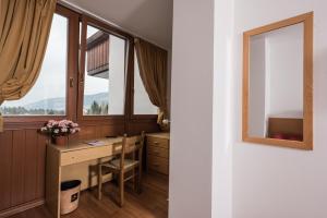 a home office with a desk and windows at Hotel Union in Dobbiaco