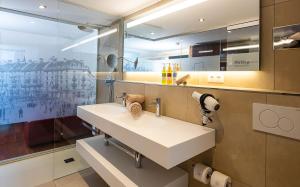 a bathroom with a white sink and a mirror at Hotel Scheuble in Zürich +37 photos
