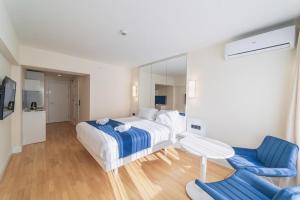 Habitación de hotel con cama y silla azul en Orbi City Towers en Batumi