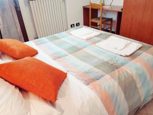 a bed with a colorful blanket and two pillows on it at Guest Holiday Filangieri 1 in Reggio Emilia
