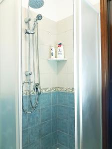 W łazience znajduje się prysznic z niebieskimi kafelkami. w obiekcie Guest Holiday Filangieri 1 w mieście Reggio nell'Emilia