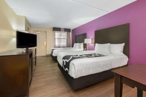 a hotel room with two beds and a flat screen tv at La Quinta Inn by Wyndham Miami Airport North in Miami