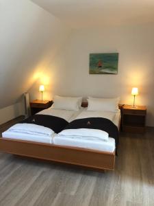 two beds in a room with two lamps on either side at Hotel Johann in Warendorf