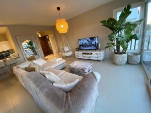 sala de estar con sofá y TV en Almaza bay Beach Town Chalet, en Marsa Matruh