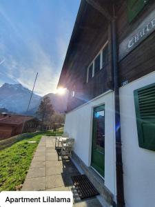 a building with a table and chairs outside of it at Apartment Lilalama in Grindelwald