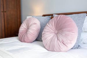 two pink pillows sitting on top of a bed at Dovedale in Ashbourne