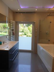 a bathroom with a tub and a sink and a shower at * * * * * Villa Zabler in Bad Schonborn