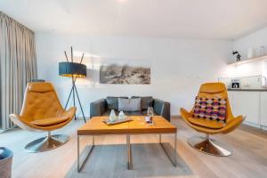 ein Wohnzimmer mit 2 Stühlen und einem Couchtisch in der Unterkunft die Strandvilla Meeresleuchten in Ostseebad Sellin