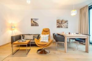 ein Wohnzimmer mit Tisch und Couch in der Unterkunft die Strandvilla Nordlicht in Ostseebad Sellin