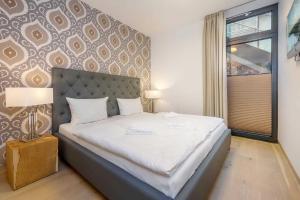 ein Schlafzimmer mit einem großen Bett mit einem großen Fenster in der Unterkunft die Strandvilla Nordlicht in Ostseebad Sellin