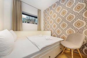 ein Schlafzimmer mit einem weißen Bett und einem Stuhl in der Unterkunft die Strandvilla Nordlicht in Ostseebad Sellin