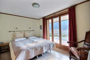 une chambre avec un lit et une grande fenêtre dans l'établissement CHALET - WIFI - SAINT JEAN D'AULPS - 10 Personnes - TAPTOP, à Saint-Jean-dʼAulps
