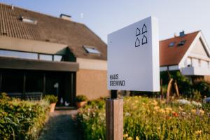 a white sign in front of a house at Vier Häuser in Norderney