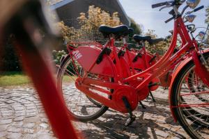 Una bicicleta roja con una canasta estacionada en una calle en Vier Häuser, en Norderney