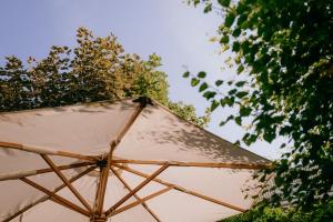 諾德奈的住宿－Vier Häuser，树旁的白色遮阳伞