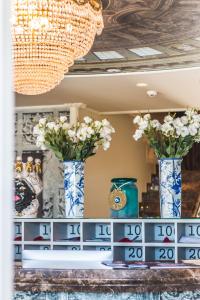two blue and white vases with flowers on a shelf at Hotel Villa Pascucci in Durrës