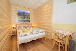 a small bedroom with a bed and a table at Apartament Krupówki 36/8 in Zakopane