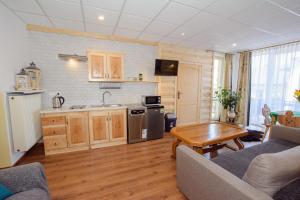 Una cocina y una sala de estar con un sofá y una mesa. en Apartament Krupówki 36/8, en Zakopane 10 fotos más
