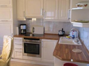 a kitchen with white cabinets and a sink at Appartementanlage Urlaubsträume in Fulgen