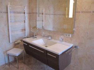 ein Badezimmer mit einem Waschbecken, einem Spiegel und einem Stuhl in der Unterkunft Appartementanlage Urlaubsträume in Fulgen