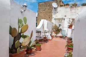 un patio con mesa, sillas y plantas en B&B Epoche' en Nápoles