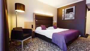 Rúm í herbergi á Hotel Restaurant Van Der Valk Nivelles-Sud