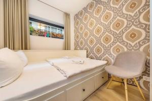um quarto com uma cama, uma cadeira e uma parede em die Strandvilla Strandgut em Ostseebad Sellin