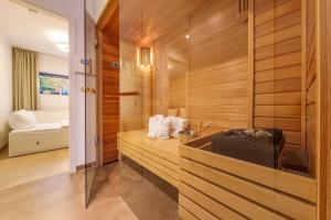 uma casa de banho com paredes de madeira, um lavatório e uma banheira em die Strandvilla Strandgut em Ostseebad Sellin