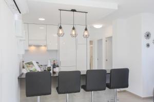 a kitchen with a table with black chairs at MyFlats-Deluxe Monte Faro in Gran Alacant