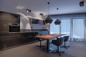 a kitchen with a wooden table and black chairs at ON Chalet Residences Mathon-Ischgl in Mathon