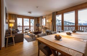 a living room with a table and chairs and mountains at Residence Miravidi La Rosiere in La Rosière