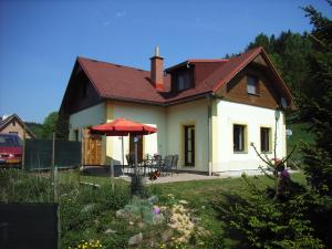 ein kleines weißes Haus mit rotem Dach in der Unterkunft Holiday House Arnultovice in Rudník