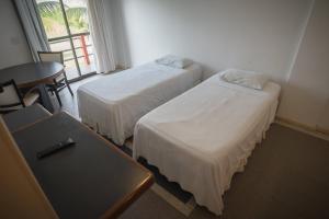 Llit o llits en una habitació de Coqueiral Praia Hotel