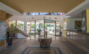 a lobby with a tree stump in the middle of a building at Coqueiral Praia Hotel in Santa Cruz