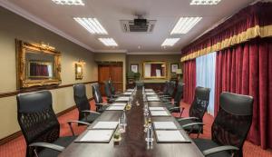 una sala de conferencias con una mesa larga y sillas en The Residence en Johannesburgo